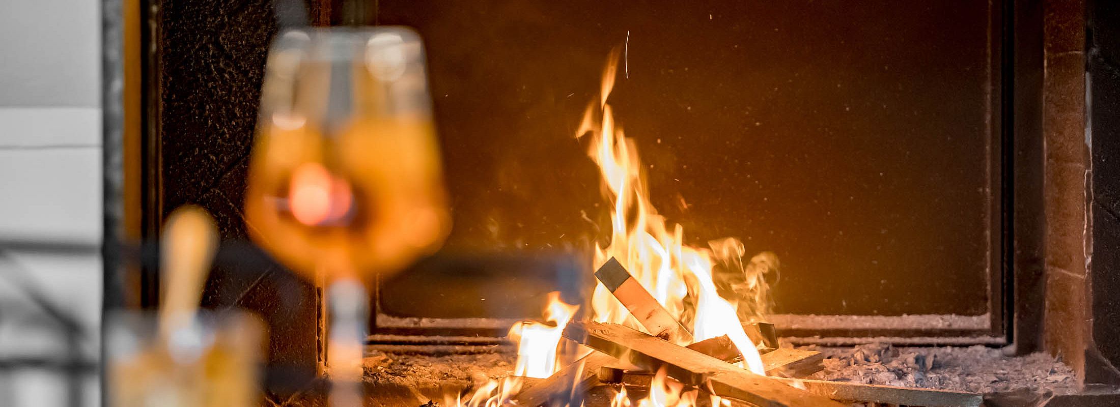 Open fireplace with crackling fire and drink in a cozy atmosphere