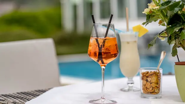 Erfrischender Sommerdrink auf der Terrasse mit Blick auf den Pool