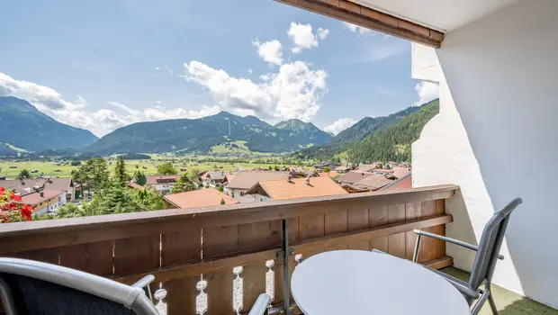 Balkon mit Sitzgruppe und traumhaftem Blick über Dächer und Berge