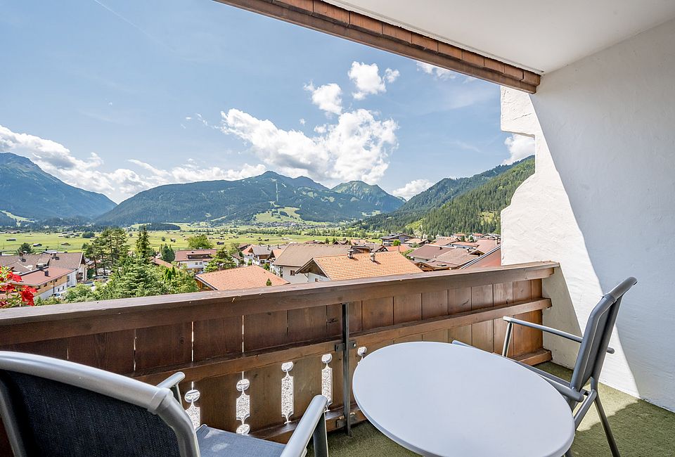 Balkon mit Sitzgruppe und traumhaftem Blick über Dächer und Berge