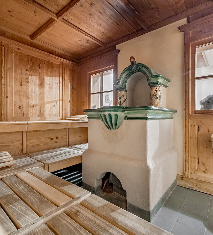 Gezellige sauna met traditionele tegelkachel en houten bekleding